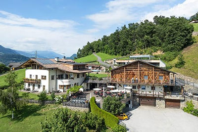 Ristorante, pizzeria e osteria contadina Pitschlmann a Fiè allo Sciliar: posizione panoramica e soleggiata con terrazza, circondata da prati e montagne, ideale per i buongustai.