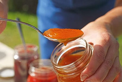 Löffel mit roter Fruchtmarmelade über offenem Glas – Verkostung bäuerlicher Hofprodukte mit dem Qualitätssiegel Roter Hahn beim FarmFood Festival im Kurhaus Meran.