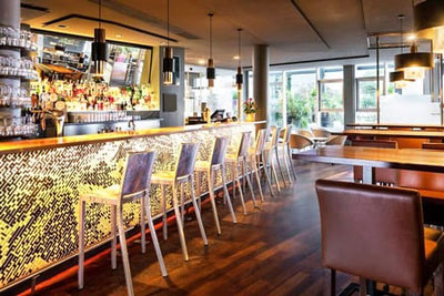 Moderne B-BAR in Bozen mit eleganter Bartheke, warmem Licht, gemütlichen Sitzbereichen und urbanem Ambiente im Four Points by Sheraton.
