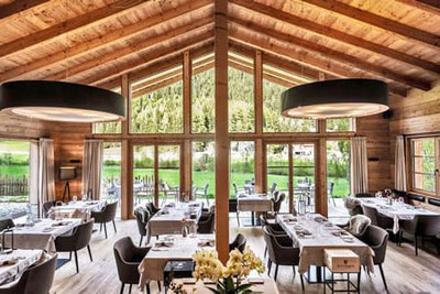 Ristorante Eggile a Valles: sala ristorante arredata con stile, con grandi finestre, vista sulla Valle di Valles in Alto Adige, atmosfera accogliente e moderna con un tocco alpino.