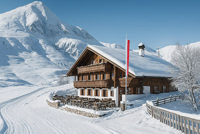 La Malga Kirchsteiger presso Merano 2000 con terrazza soleggiata, stube e cucina altoatesina – circondata da piste da sci, cime innevate e sentieri escursionistici, ideale per escursionisti e buongustai.