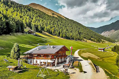 Die Großberghütte im sonnigen Altfasstal oberhalb von Meransen – umgeben von grünen Wiesen, Bergen und Wäldern, idealer Ort zum Wandern und Genießen in Südtirol.