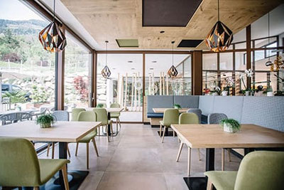 Moderna sala ristorante presso il Ristorante & Pizzeria Camping Passeier a Saltusio, con ampie vetrate, ambiente luminoso, arredamento elegante e atmosfera accogliente.