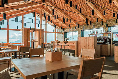 Moderno ristorante di montagna Pichlberg a S. Martino con arredamento in legno, finestre panoramiche, zona bar e ampia vista sulle montagne altoatesine della Val Sarentino.