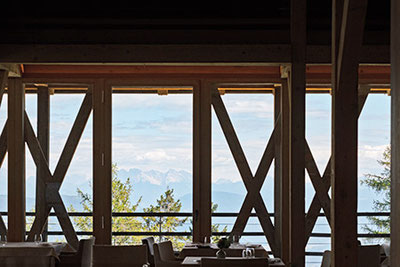 Vista della luminosa sala da pranzo panoramica del Ristorante 1500 dell'Hotel Vigilius Mountain Resort sul Monte San Vigilio a Lana, in Alto Adige.