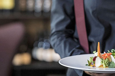Eine Kellnerin vom Wirtshaus Restaurant Löwengrube in Bozen beim Event-&-Catering-Service in Südtirol