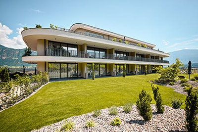 Modernes Apartmenthaus Belia Lofts in Eppan mit stilvoller Architektur, großen Panoramafenstern, gepflegtem Garten und herrlichem Blick auf das Südtiroler Etschtal.