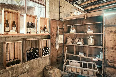 Rustikaler Hofladen am Huberhof in Völs am Schlern mit hausgemachtem Wein, Essig, Getreide und regionalen Bio-Produkten in Holzkisten – authentisch, nachhaltig und charmant.