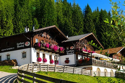 Gasthaus Haashof a Videgg vicino Scena con tradizionale architettura altoatesina, balconi fioriti e posizione panoramica soleggiata.