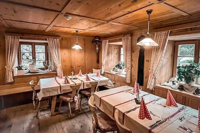 Accogliente stube altoatesina al Gorgeler Bar & Steakhouse di Racines con tavoli apparecchiati con cura, arredi in legno e luci calde: un luogo dove sentirsi a proprio agio e godersi la vita.