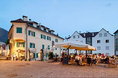 Trattoria Al Boia a Merano con un'accogliente atmosfera serale sulla terrazza.