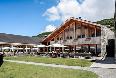 Moderno ristorante di montagna Pichlberg a S. Martino con arredamento in legno, finestre panoramiche, zona bar e ampia vista sulle montagne altoatesine della Val Sarentino.
