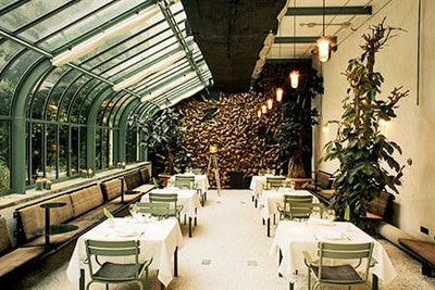 Restaurant ConTanima im Parkhotel Laurin Bozen: stilvoller Wintergarten mit Glasdach, gedeckten Tischen, Pflanzen und modernem Ambiente