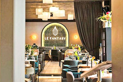 Interni eleganti del ristorante Lè Fantasy a Bolzano con design moderno, illuminazione suggestiva, tavoli apparecchiati e atmosfera raffinata per l'aperitivo.