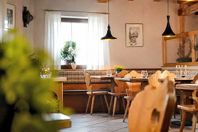 Accogliente sala da pranzo del Ristorante & Caffè Cutraun a Parcines, con arredi tradizionali in legno, atmosfera calda e ospitalità altoatesina.
