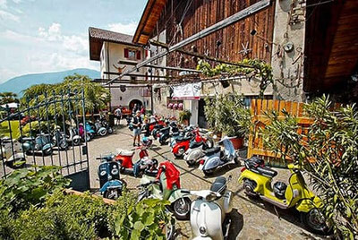 Hilberkeller Kuens – Vespatreffen mit bunten Vespas im Innenhof des Restaurants, gesellige Atmosphäre und Event in Südtirol