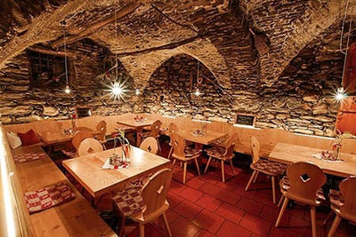 Storica cantina in pietra del Hilberkeller a Caines presso Merano – atmosfera rustica, sale accoglienti e ospitalità altoatesina in mura secolari.