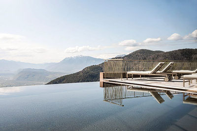 Piscina a sfioro dell'Hotel Belvedere a San Genesio con vista panoramica sulla Valle dell'Adige e sulle Dolomiti: tranquillità, sole e relax sui tetti di Bolzano.