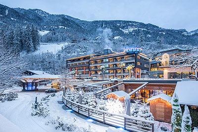 Vista esterna del Quellenhof Luxury Resort Passeier, San Martino in Alto Adige in inverno con neve e luci