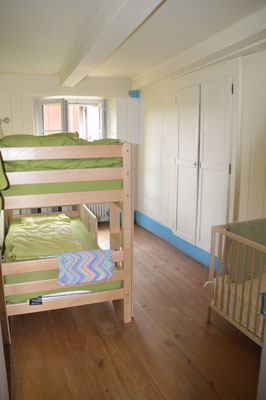 Schlafzimmer mit Etagenbett und Babybett