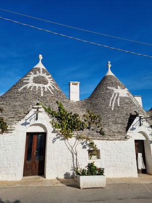 Die Symbole auf den Dächern der Trulli dienten, insbesondere auf dem Land, der Wiedererkennung (ähnlich einem Namensschild) oder hatten religiöse Bedeutung und sollten das Haus vor dem Bösen schützen.