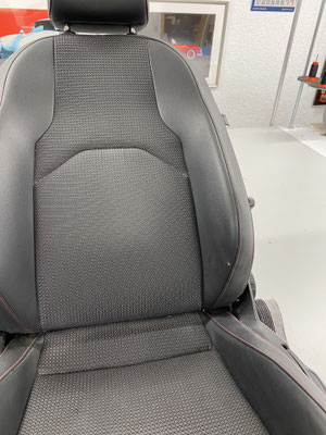 Fahrersitz eines Seat Leon FR. Das Kunstleder an der Einstiegswange wurde beschädigt.