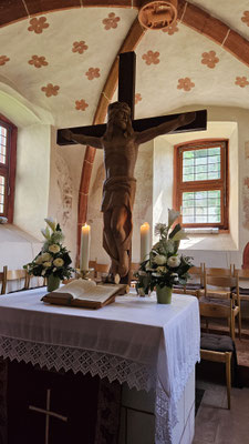 Die mächtige Skulptur des gekreuzigten Jesus auf dem Altar irritiert bei genauer Betrachtung. Jesus, so Pfarrer Kuhnke, ist als König dargestellt: kein toter, sondern ein auferstandener Jesus.
