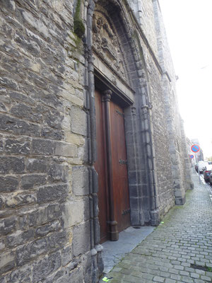 Doornik - Een of meer energielijnen gaan in de Rue des Jésuites, aan de westzijde van de Sint-Piatkerk, onder het reliëf van het Lam op het Boek met de Zeven Zegels door. Het groene briefje achteraan is een keer naar buiten toe omgewaaid.