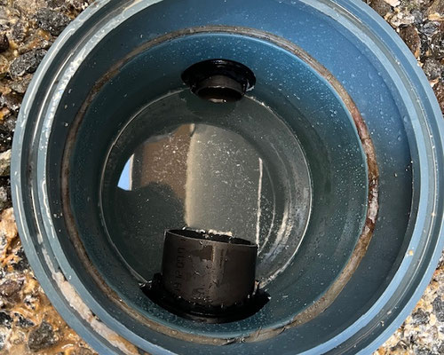 排水トラブル現場で、溜枡に沈殿した汚泥を丁寧に汲み上げている様子。除菌洗浄とエルボの復旧作業に進む前の重要な工程。