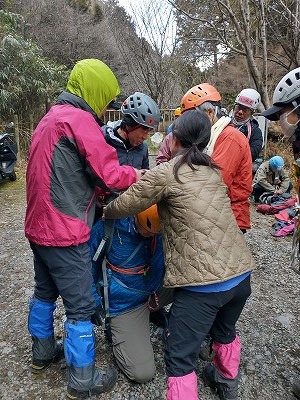 ザックとカッパを使って徒手搬送です。背負う人の体型に合わせてザック紐を調節することが大事ですね。立ち上がる時はふらつかないように、前を支えるようにしましょう。