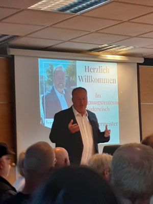Uwe Santjer spricht vor mehreren Menschen im BZ