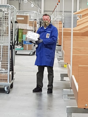 FInsp MÖRTL beim Einräumen der Pakete von der Rutsche in den Rollcontainer