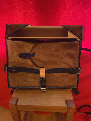 En haut, la boite à paquet de cartouches. Le sac doit sa forme carrée à un cadre-ossature en bois