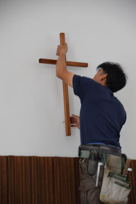 2020年5月19日（火）昼前　大工さんが事前の準備をそうとう慎重になさって、一気に十字架の位置を高く白壁に移動して頂く工事を40分程の時間をかけてなさいました。仕事ぶりを全部みていましたが、見事です。