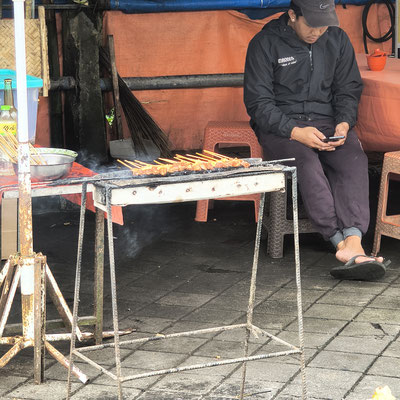 Street food bereiding van sate op een traditionele grill 