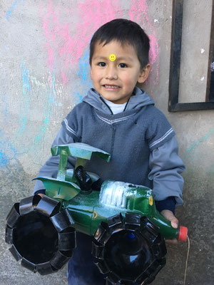 Yovani mit seinem aus Plastikflaschen gebastelten Traktor