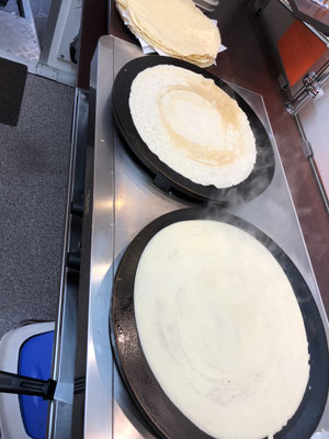 zwei große Crêpesplatten mit Crêpes darauf