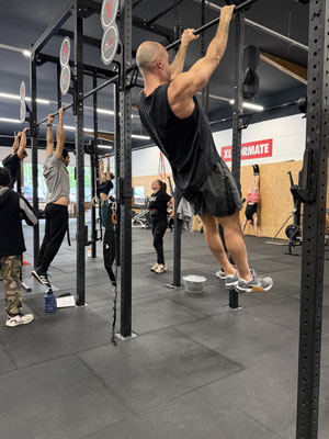 Teilnehmer beim Calisthenics Kurs in Mainz machen Pull-ups im Fitnessstudio.