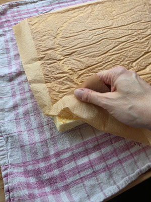 Backpapier vom Biskuitteig abziehen