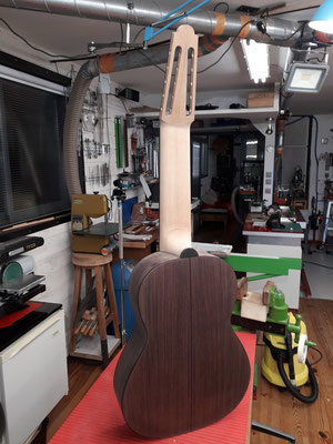 Back view of a 10-string guitar vertically positioned on the workbench in Hervé Lahoun-H441guitare's workshop