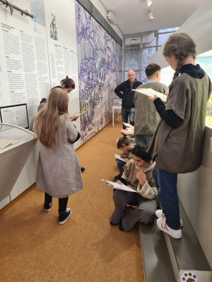 Kinder stehen mit Quizzetteln in der Hand im Musum.