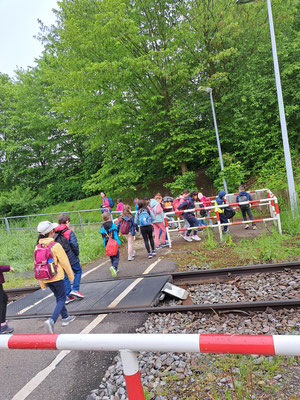 Die Klasse überquert einen Bahnübergang mit Schranke.