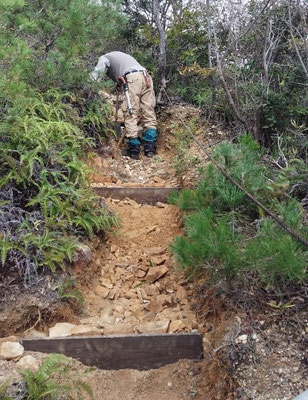 雨水で洗掘された箇所に杉板でステップを新設し、雨水を登山路の脇に逃がす工夫