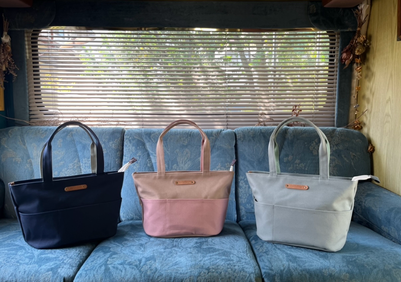 帆布お仕事バッグ、Picnicの肩掛けタイプのバッグでネイビー、ベージュ×アッシュピンク、ライトグレーのバッグが３点キャンピングカーの後部座席のブルーのシートに並んでいます。