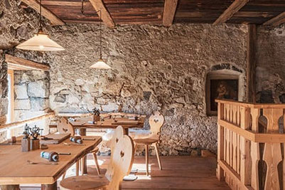Accogliente stube nello storico Huberhof a Fiè allo Sciliar con pareti in pietra naturale, interni in legno e dettagli curati – ambiente rustico con vista sullo Sciliar.