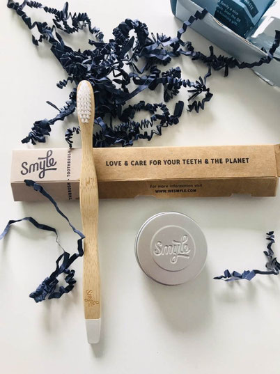 ecological way of cleaning your teeth - wooden toothbrush and a metal container with toothpaste tablets