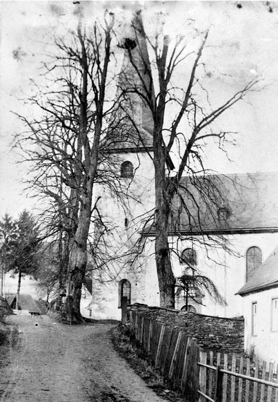 Historisches Foto der Pfarrkirche St. Peter und Paul zu Eslohe, rechts im Vordergrund erkennt man das Pfarrhaus von 1688