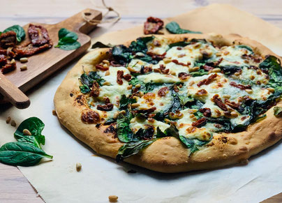 Pizza mit Spinat, Burrata, getrockneten Tomaten & Pinienkerne