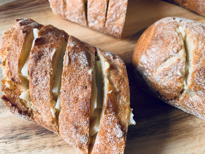 Baguette diagonal einschneiden und mit der Knoblauchbutter bestreichen & mit Käse befüllen