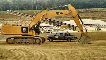 Raveling Companies bucket at work site on CAT excavator.